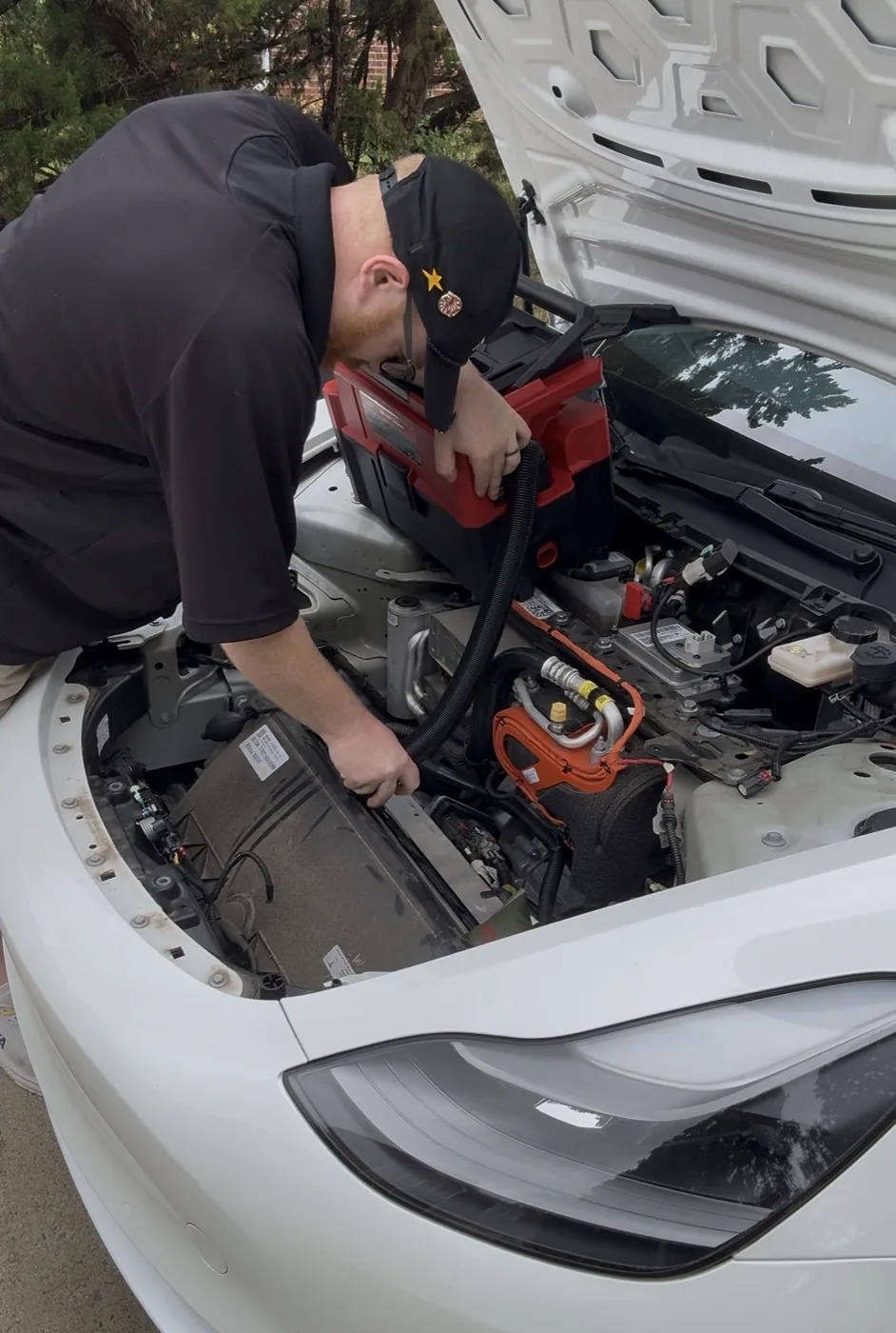 Aaron performing hands-on service under the hood of a Tesla