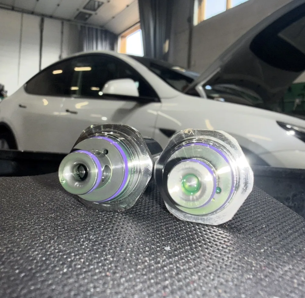 Replacement vehicle components displayed in front of a Tesla